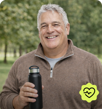 Paciente sonriendo al aire libre con su botella de agua